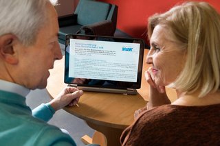 Älteres Paar nutzt ein Tablet, sie schauen sich eine Online-Beitrittserklärung des VdK an. 