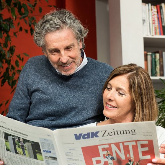 Ein Mann und eine Frau schauen gemeinsam in die VdK-Zeitung, auf der Titelseite geht es um das Thema Rente