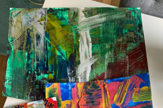 Das Foto zeigt Ausschnitte einer farbenfrohen Acrylmalerei in Grün-, Blau-, Grau- und Schwarztönen sowie einen Ausschnitt eines zweiten Bildes in Pink, Gelb und Blau.
