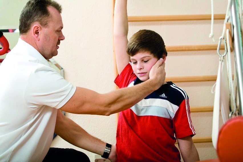 Auf dem Foto ist ein Junge bei der Physiotherapie in einer Kinder- und Jugendambulanz zu sehen.