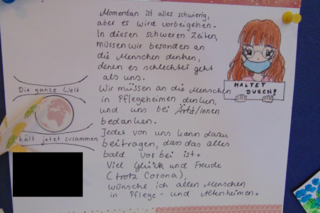 Das Bild zeigt einen Brief mit einer Zeichnung. Auf dieser ist ein Mädchen in Maske zusehen, die ein Plakat hochhält auf dem zu lesen ist: Haltet durch!