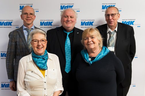 Auf dem Foto ist der Vorstand zu sehen vor einer VdK-Fotoleinwand.