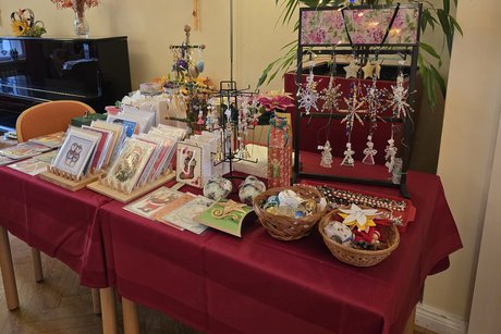 KV Steglitz-Zehlendorf Basar 2024 Tisch mit handgemachten Weihnachtsdekorationen und Grußkarten auf rotem Tuch.