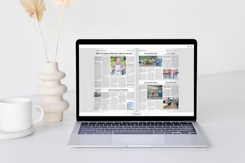 Laptop auf einem wei&szlig;en Tisch mit ge&ouml;ffneter digitaler Ausgabe der VdK-Zeitung Berlin-Brandenburg, daneben wei&szlig;e Tasse und wei&szlig;e Vase mit getrockneten Pflanzen.