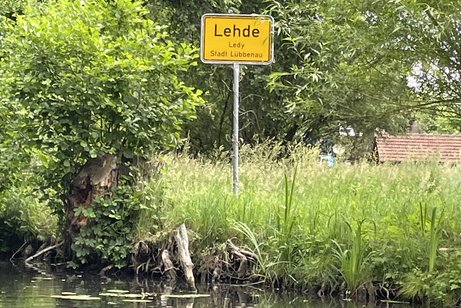 Ein Ortsschild von einer Stadt im Spreewald am Kanalufer