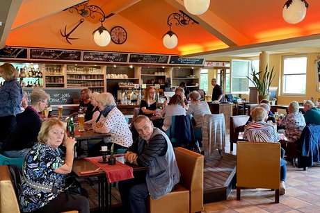 Wir warten aufs Mittagessen Leute sitzen an Tischen und warten auf Essen undTrinken