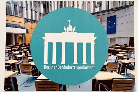 Foto mit rundem Aufdruck Berliner Behindertenparlament