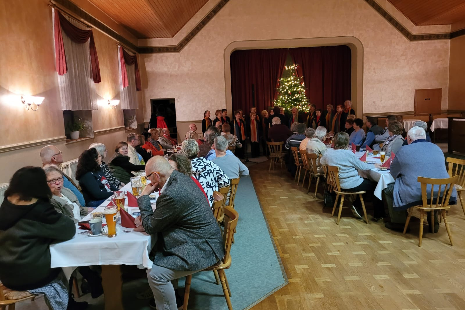 Viele Gäste sind zur Weihnachtsfeier gekommen und der Frauenchor singt Weihnachtslieder