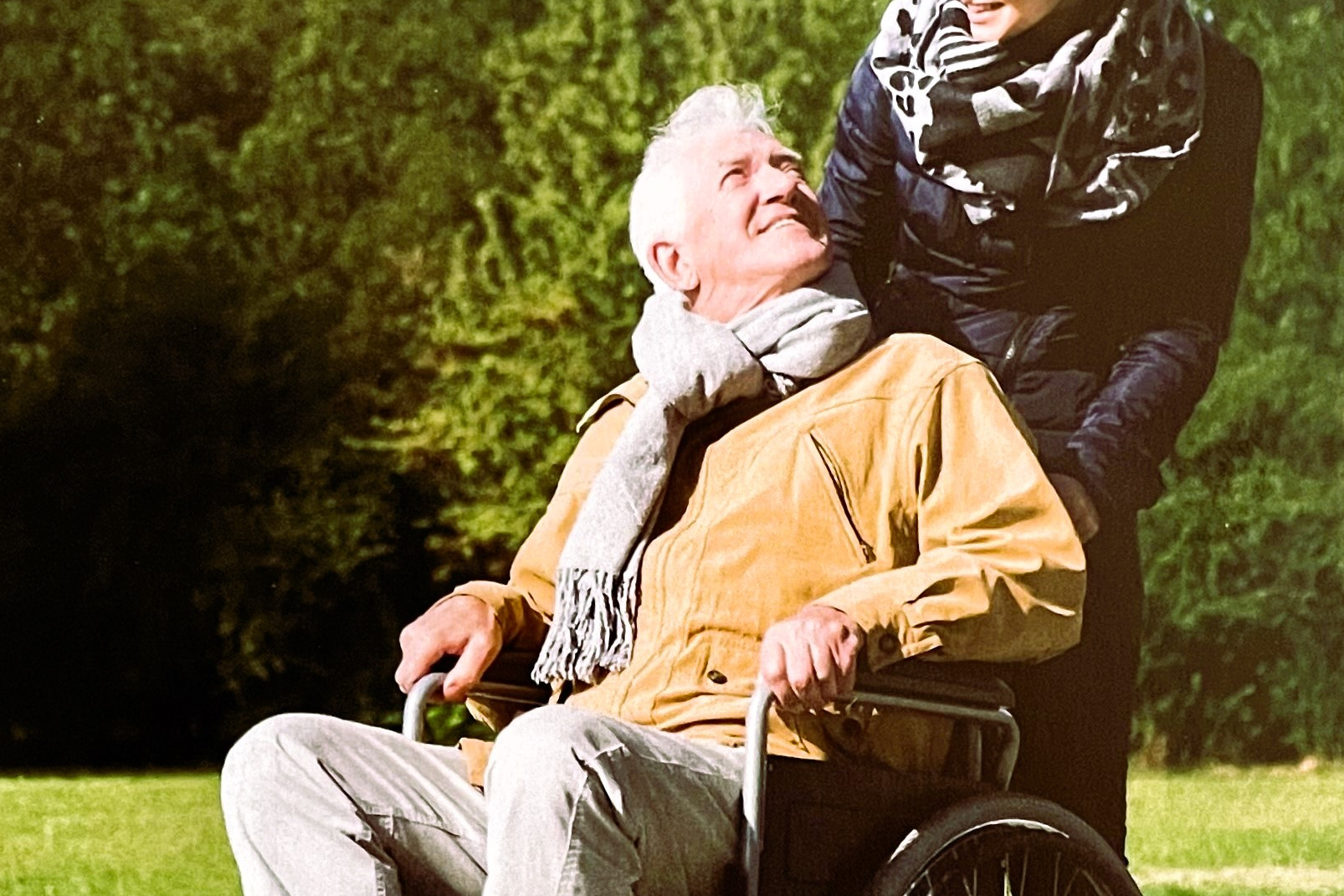 Mobilitätshilfe Mitarbeiterin vom Mobilitätshilfedienst schiebt einen Rollstuhl